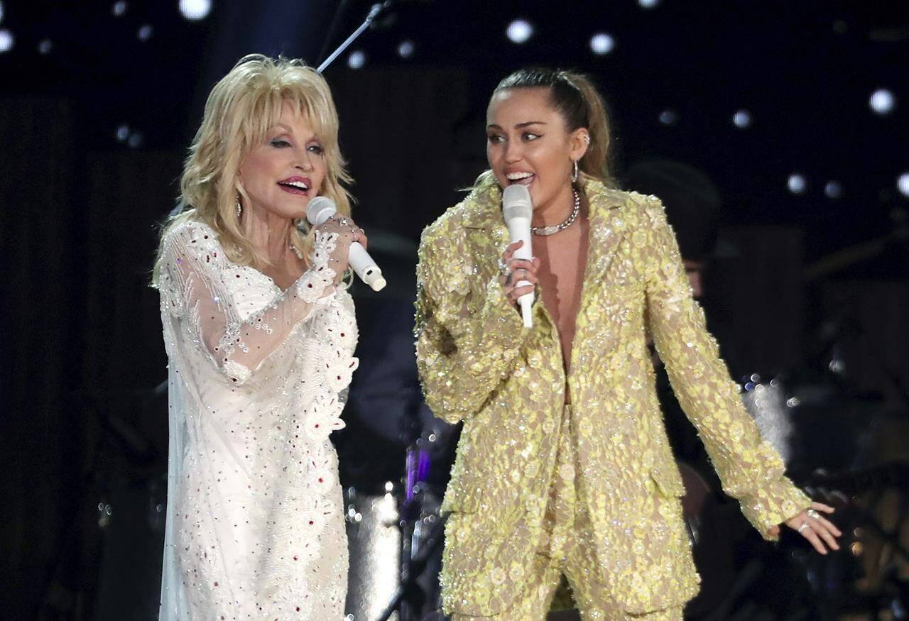 FILE - Dolly Parton, left, and Miley Cyrus perform “Jolene” at the 61st annual Grammy Awards in Los Angeles on Feb. 10, 2019. Administrators at Heyer Elementary School in Waukesha, Wis., aren’t letting a first-grade class perform “Rainbowland,” a Cyrus and Parton duet from Cyrus’ 2017 album “Younger Now,” promoting LGBTQ acceptance, because they say the song could be seen as controversial. (Photo by Matt Sayles/Invision/AP, File)