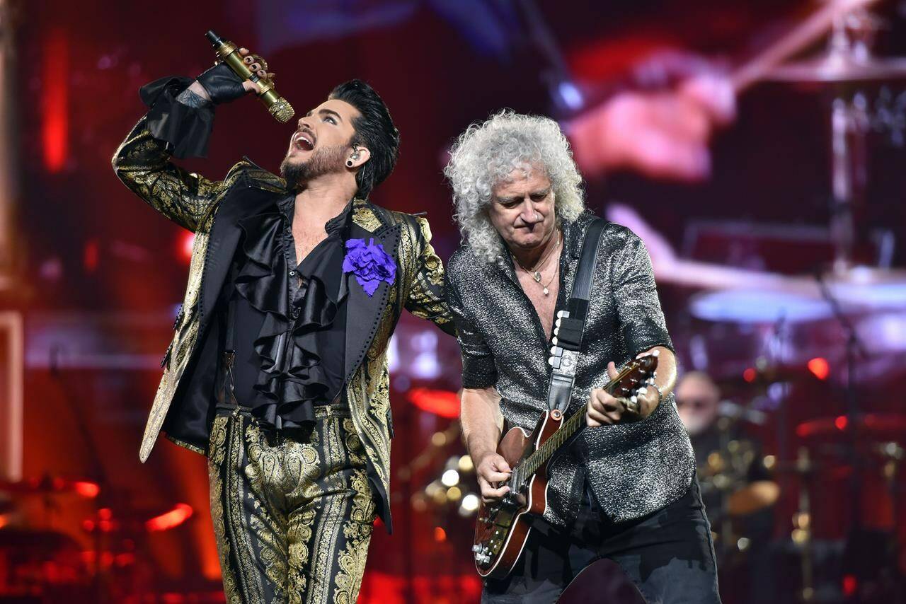 FILE - Adam Lambert, left, and Brian May of Queen + Adam Lambert perform in Chicago on Aug. 9, 2019. The band is hitting the road this fall for a North American expansion of their Rhapsody Tour. The tour will make 14 stops throughout the U.S. and Canada, including shows in New York, Boston, Toronto, Chicago, Nashville and Dallas, before closing out at Los Angeles in November. (Photo by Rob Grabowski/Invision/AP, File)