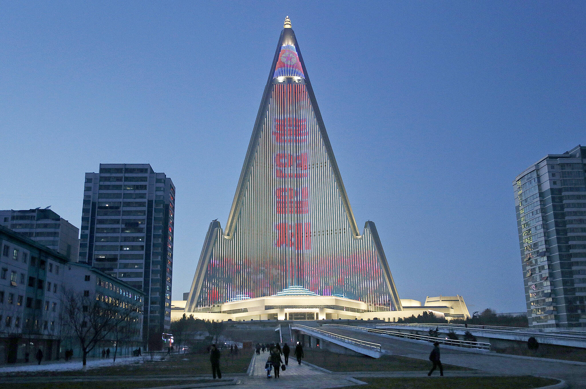 In this Dec. 20, 2018, photo, the facade of the pyramid-shaped Ryugyong Hotel lights up in Pyongyang, North Korea. (AP Photo/Dita Alangkara)