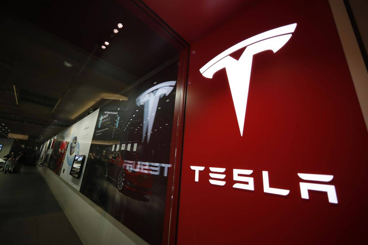 FILE - A sign bearing the Tesla company logo is displayed outside a Tesla store in Cherry Creek Mall in Denver, Colorado, Feb. 9, 2019. Tesla’s first-quarter vehicle sales in 2023 rose 36% after the company cut prices twice in a bid to stimulate demand. (AP Photo/David Zalubowski, File)