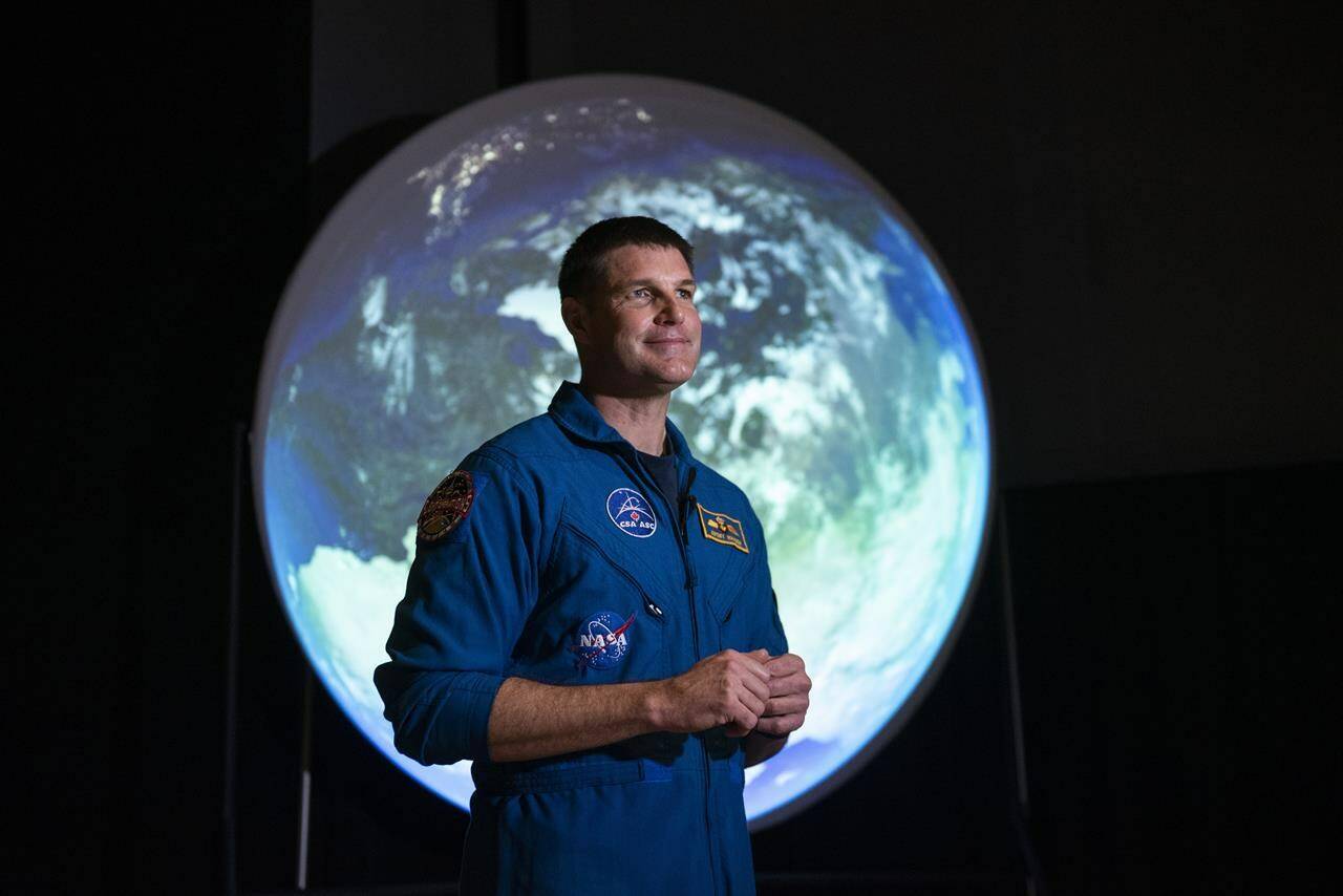 Canadian Space Agency astronaut Jeremy Hansen stands in front of a display as he participates in an interview at the opening of Earth in Focus: Insights from Space, a new exhibition at the Canada Science and Technology Museum in Ottawa, on Friday, Nov. 26, 2021. Hansen, a colonel and CF-18 pilot in the Royal Canadian Air Force, has been selected to become the first Canadian to venture into deep space.THE CANADIAN PRESS/Justin Tang