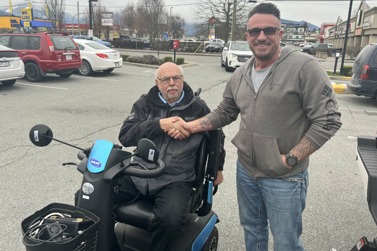 Jonathan Neufeld (right) and the mobility scooter he donated to Wayne Pavich on March 31, 2023 after finding out Pavich’s scooter was stolen from a shed at his home. (Paul Henderson/ Chilliwack Progress)