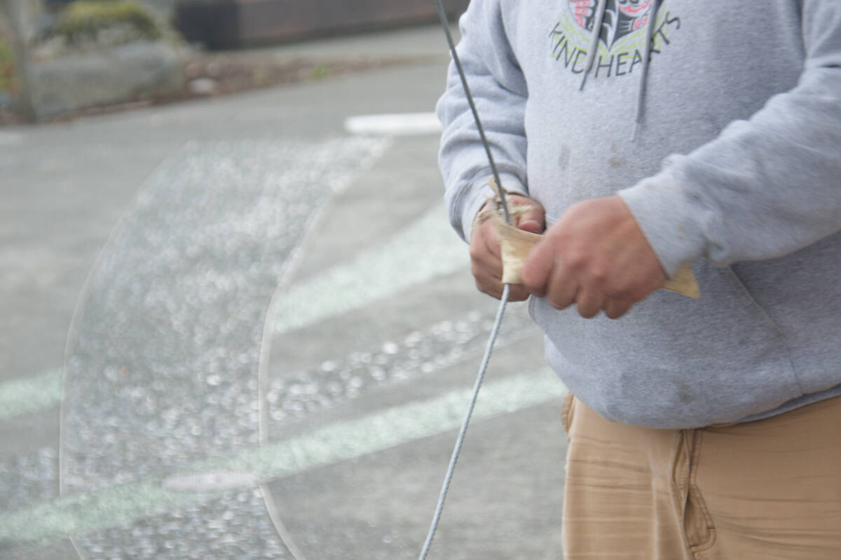 Shawn DeCaire shows how to soften up a rawhide using cable. Photo Edward Hitchins/Campbell River Mirror