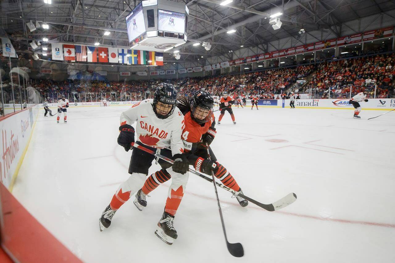 Canada forward Sarah Nurse (20) and Japan defender Ayaka Hitosato (4) chase a puck into the corner during first period IIHF Women’s World Hockey Championship hockey action in Brampton, Ont., on Saturday, April 5, 2023. THE CANADIAN PRESS/Cole Burston