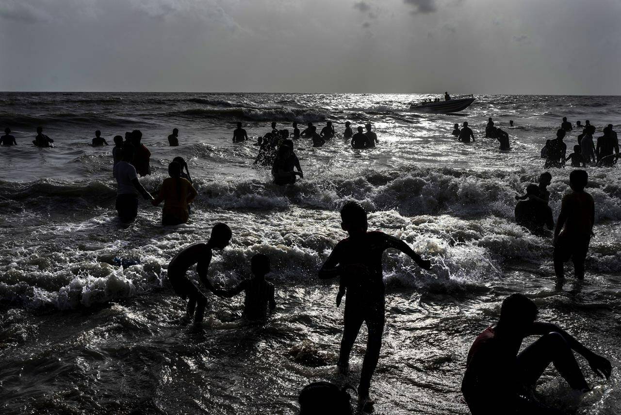 FILE - Children play at a crowded Juhu beach on the Arabian Sea coast on a hot and humid day in Mumbai, India, May 22, 2022. Demographers are unsure exactly when India will take the title as the most populous nation in the world because they’re relying on estimates to make their best guess. (AP Photo/Rafiq Maqbool, File)