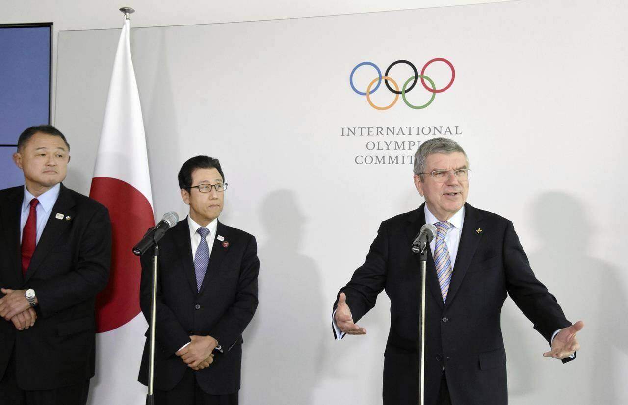 Japanese Olympic Committee President Yasuhiro Yamashita, from left, and Sapporo Mayor Katsuhiro Akimoto listen to International Olympic Committee President Thomas Bach, right, speak during a news conference in Lausanne, Switzerland, on Jan. 11, 2020. Sapporo’s bid for the 2030 Winter Olympics has been slowed, but not stopped, by fallout from the still-developing corruption scandal around the 2020 Tokyo Games. (Masashi Inoue/Kyodo News via AP)