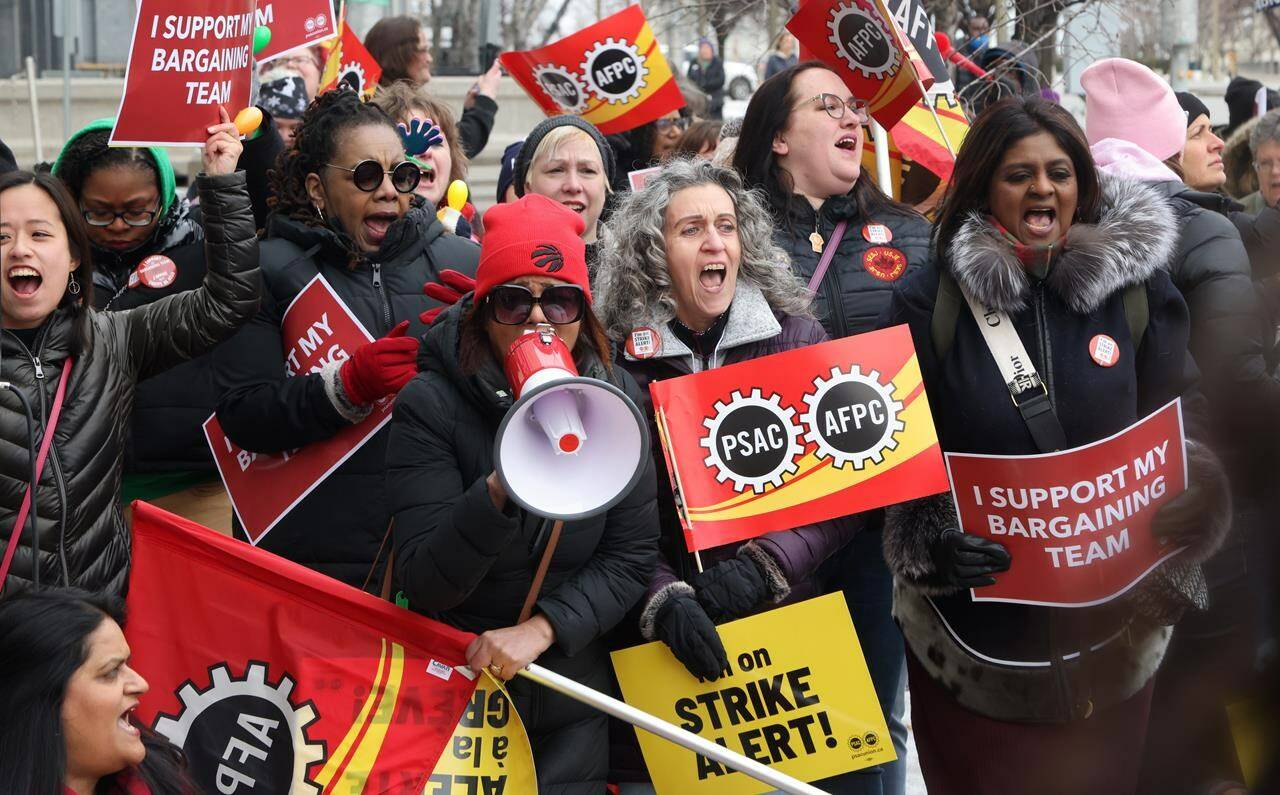Members of the Public Service Alliance of Canada (PSAC) demonstrate outside the Treasury Board building in Ottawa on Friday, March 31, 2023. The union that represents over 120,000 public servants has voted in favour of a national strike mandate. THE CANADIAN PRESS/ Patrick Doyle