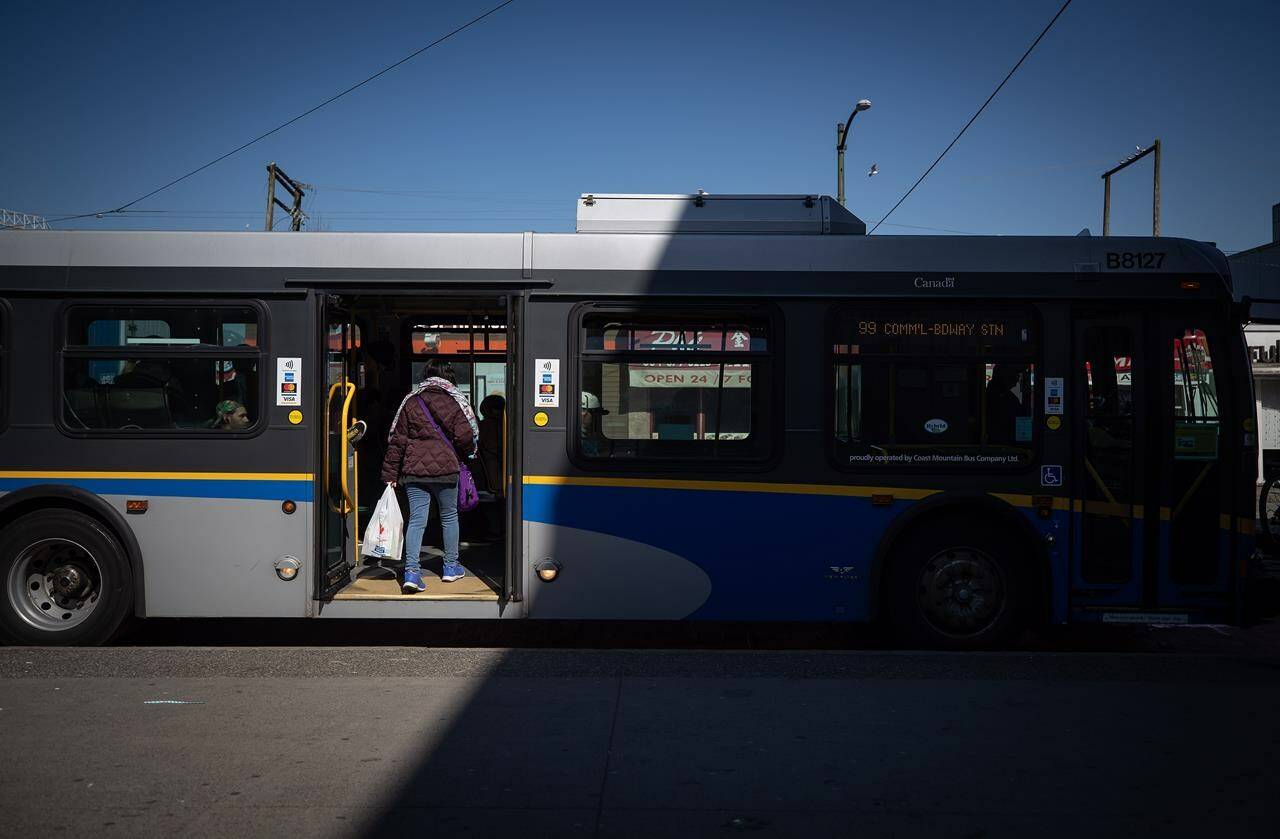 A woman boards a transit bus in Vancouver, on Friday, March 20, 2020. Bus drivers in West Vancouver say they are the latest to experience violence on the public transit system. THE CANADIAN PRESS/Darryl Dyck