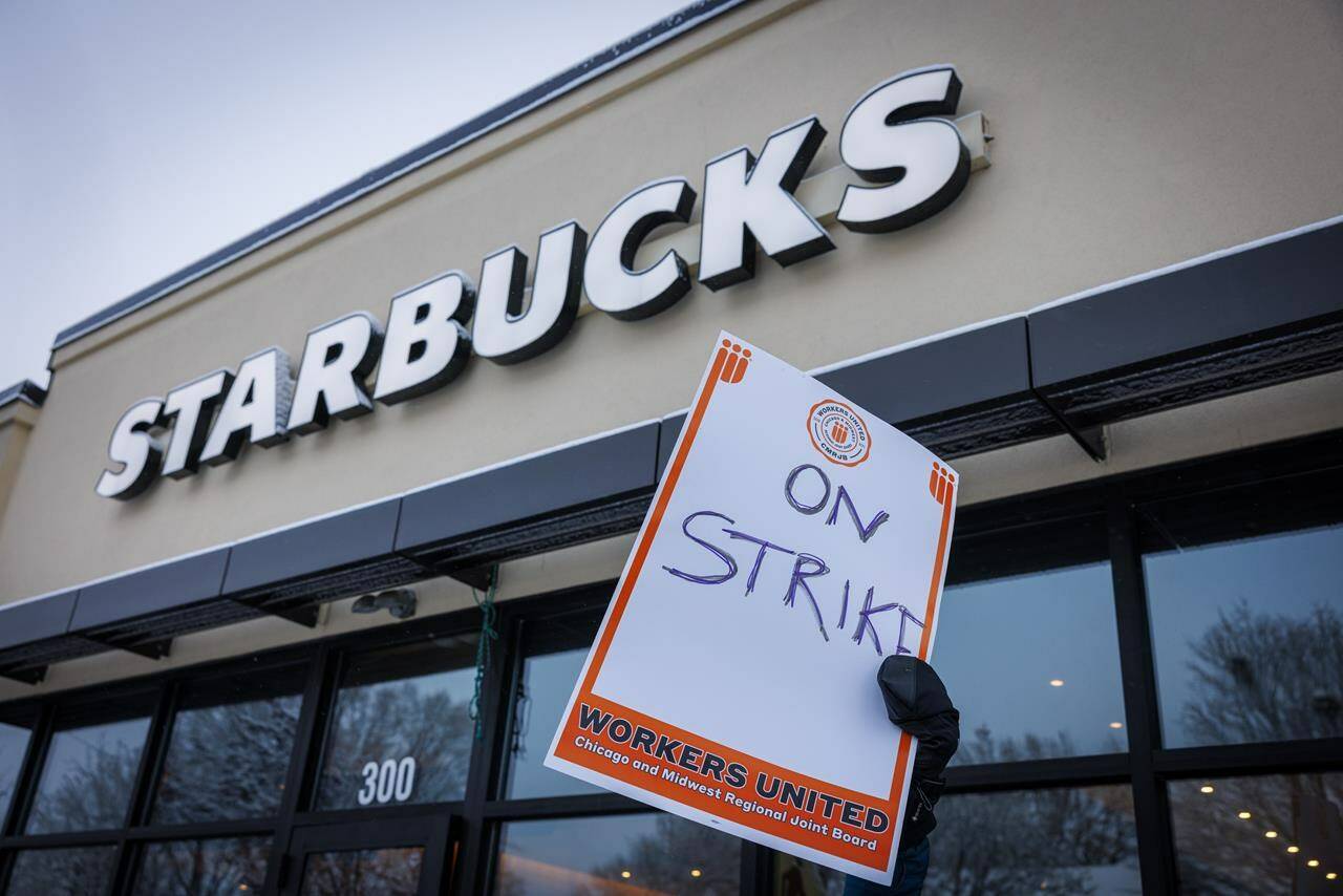 A Starbucks worker holds a sign that reads “on strike” during the “Unfair Labor Practice Strike” in St. Paul, Minn. on Friday, Dec. 16, 2022. The tight labour market could boost the pandemic-born trend of union organizing in under-unionized sectors like retail and service, which has seen successful drives at the likes of Starbucks, Indigo and PetSmart, experts said. THE CANADIAN PRESS-AP-Kerem Yucel /Minnesota Public Radio via AP