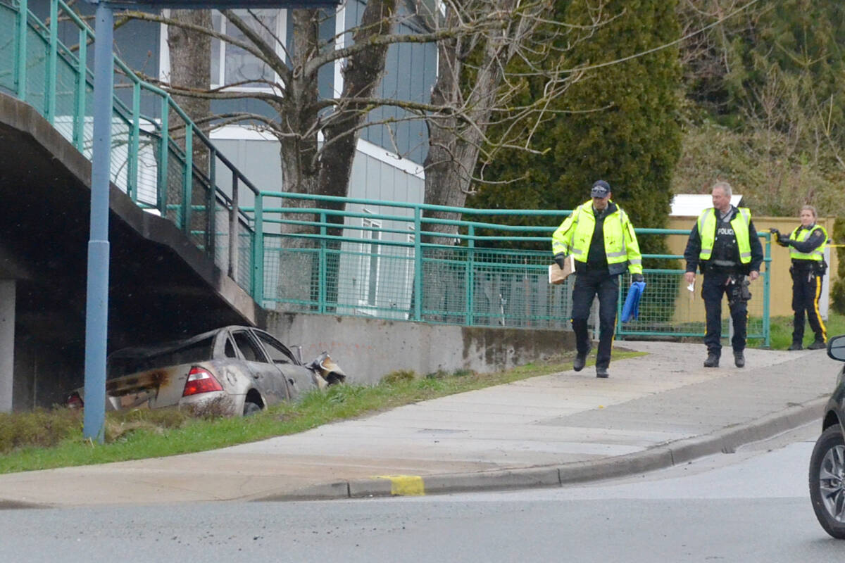 RCMP officers at the scene of a fatal collision on Sunday morning, where the vehicle became wedged under a pedestrian overpass ramp in the 6800 block of 200th Street. (Matthew Claxton/Langley Advance Times)