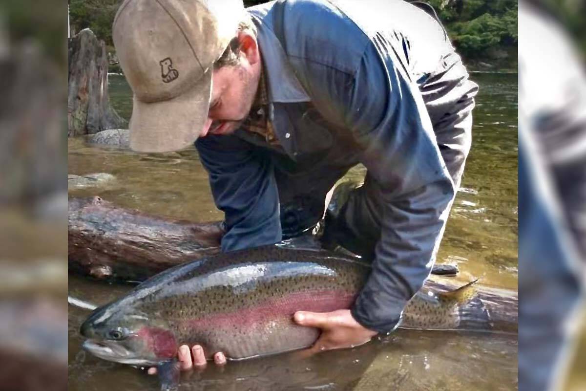 Angler and fishing guide Pat Demeester holds an abnormally large and invasive farmed rainbow trout that has escaped into Lois Lake near Powell River, B.C. (Photo courtesy Pat Demeester)