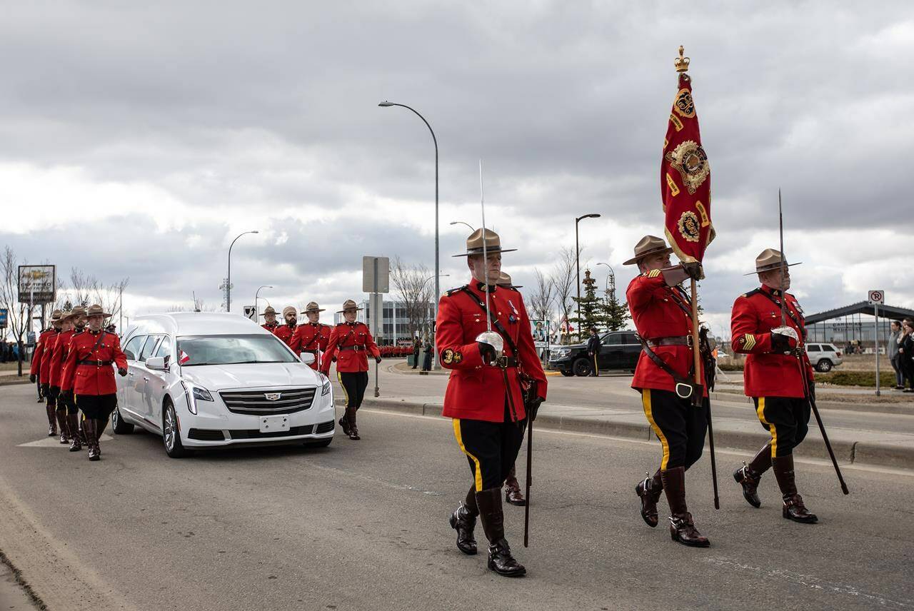 RCMP officers march along the hearse during the procession for RCMP Const. Harvinder Singh Dhami in Sherwood Park, Alta., on Thursday April 20, 2023. Dhami, a member of the Strathcona County detachment east of Edmonton, died while driving to assist colleagues with a noise complaint. THE CANADIAN PRESS/Jason Franson