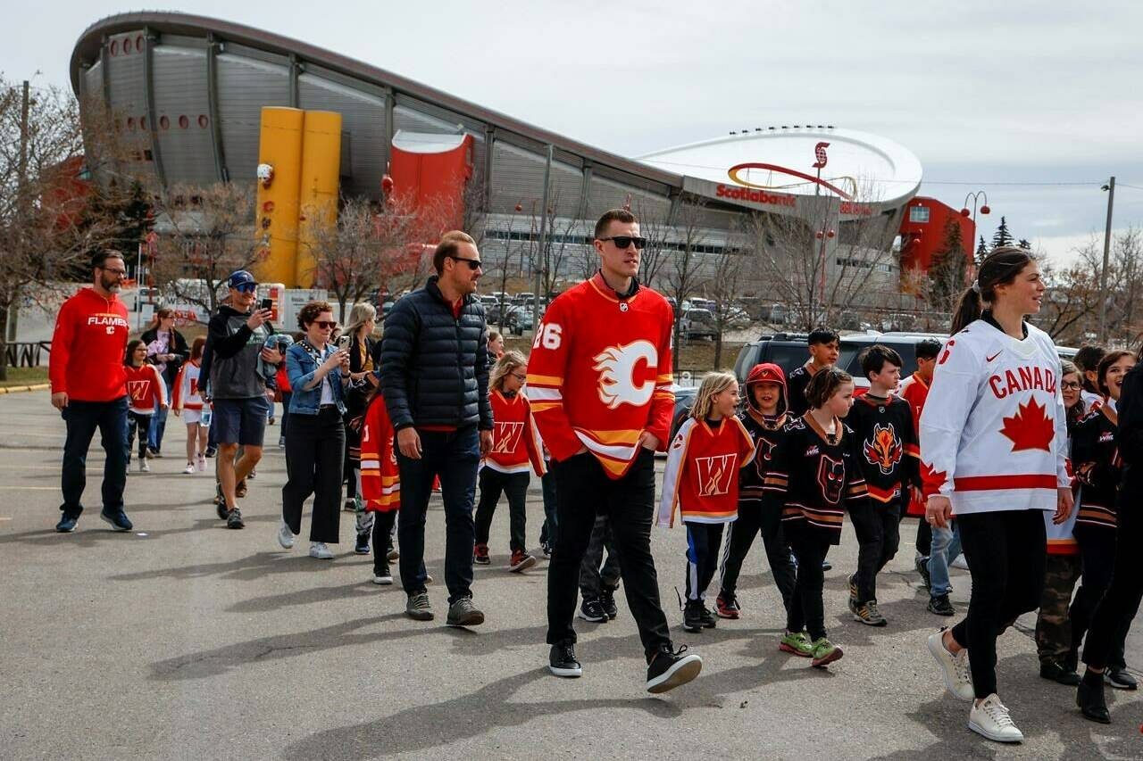 Calgary Flames’ Michael Stone, centre, and Canadian women’s team member Rebecca Johnston arrive with others for an announcement on plans for an events centre to replace the aging Saddledome, in Calgary, Tuesday, April 25, 2023.THE CANADIAN PRESS/Jeff McIntosh