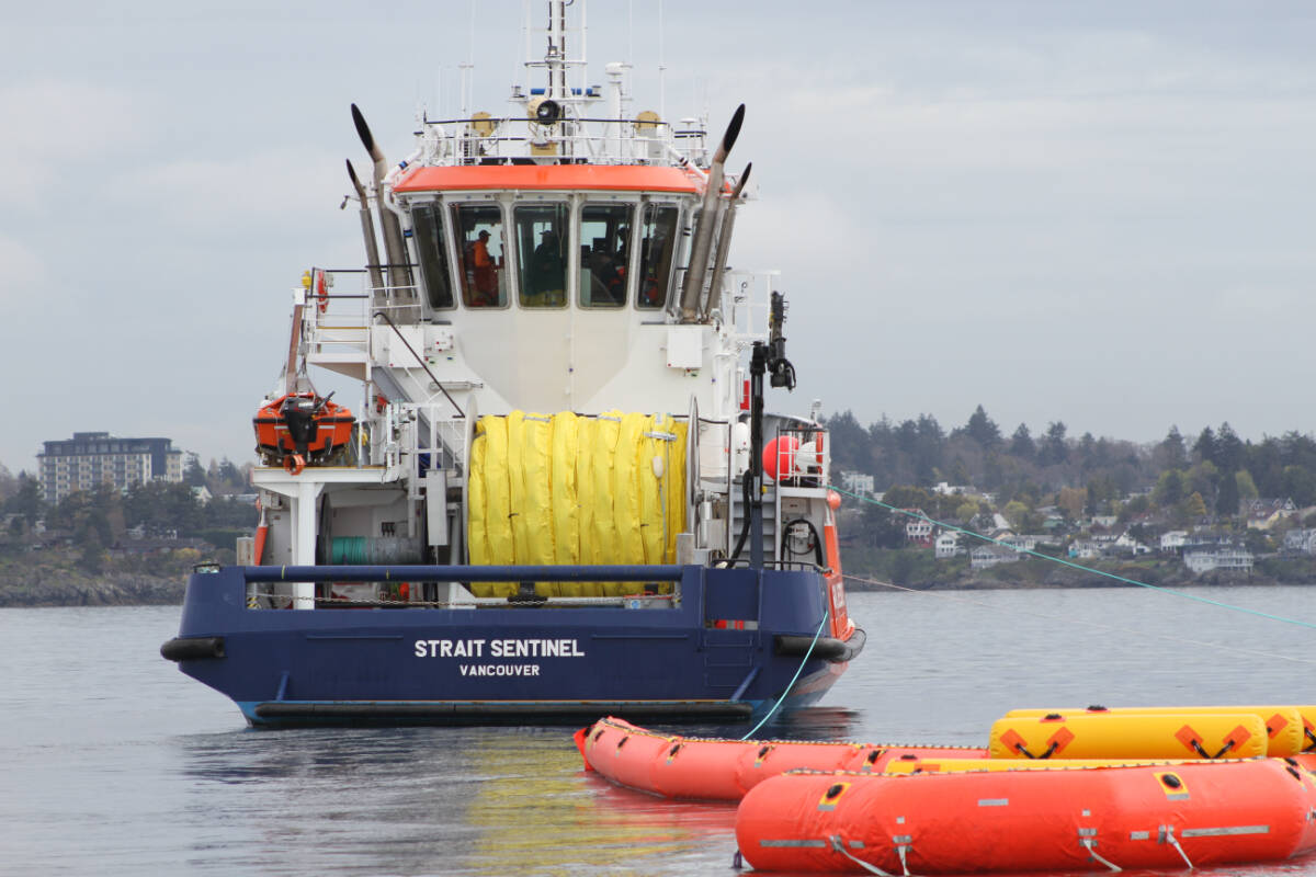 The crew of the Strait Sentinel deploys a sweep system used to collect oil off the ocean’s surface. (Austin Westphal/News Staff)