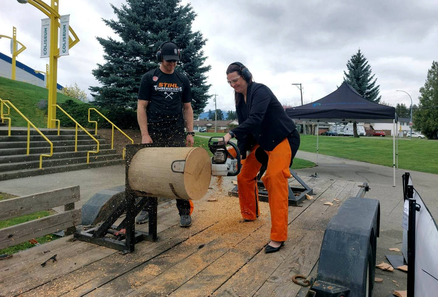 With Stihl Timbersports athlete Stirling Hart watching, Chilliwack Chamber of Commerce executive director Leanna Kemp fires up a chainsaw and cuts through a log. Hart was in town Monday (April 24) to promote the Stihl Timbersports National Championship, which is coming to Chilliwack Aug. 12-13, 2023. (Eric J. Welsh/ Chilliwack Progress)