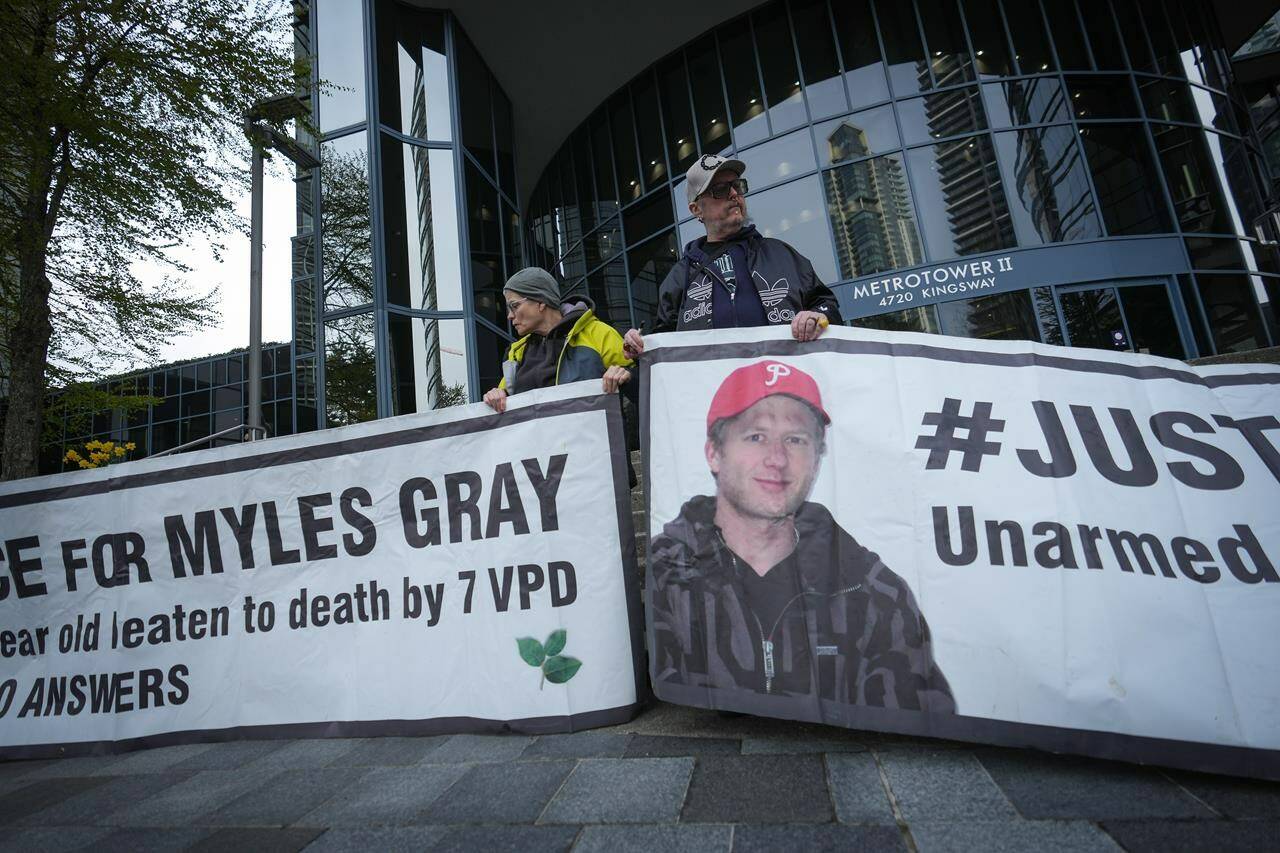 Protesters hold banners with a photograph of Myles Gray, who died following a confrontation with several police officers in 2015, before the start of a coroner’s inquest into his death, in Burnaby, B.C., on Monday, April 17, 2023. The coroner presiding over the inquest says he won’t allow the jury to see a photograph showing injuries at the time the 33-year-old died, because the application was made too late in the process. THE CANADIAN PRESS/Darryl Dyck