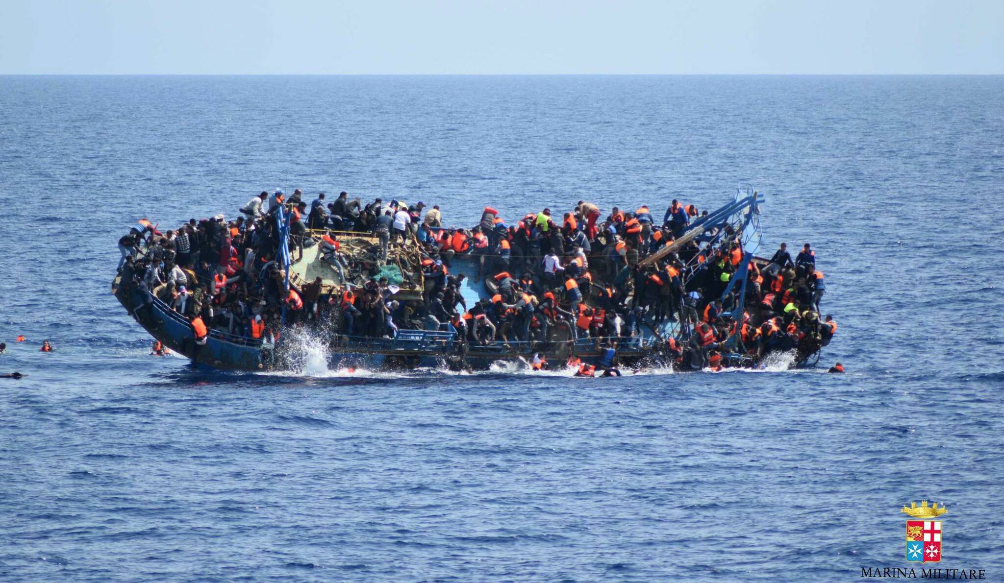 FILE - Tunisia’s coast guard says it has recovered around 210 bodies of migrants under two weeks that have washed up on the North African country’s central coastline amid an ongoing increase in <a href="https://apnews.com/hub/migration">migration</a>. People jump out of a boat right before it overturns off the Libyan coast May 25, 2016. (Marina Militare via AP Photo)