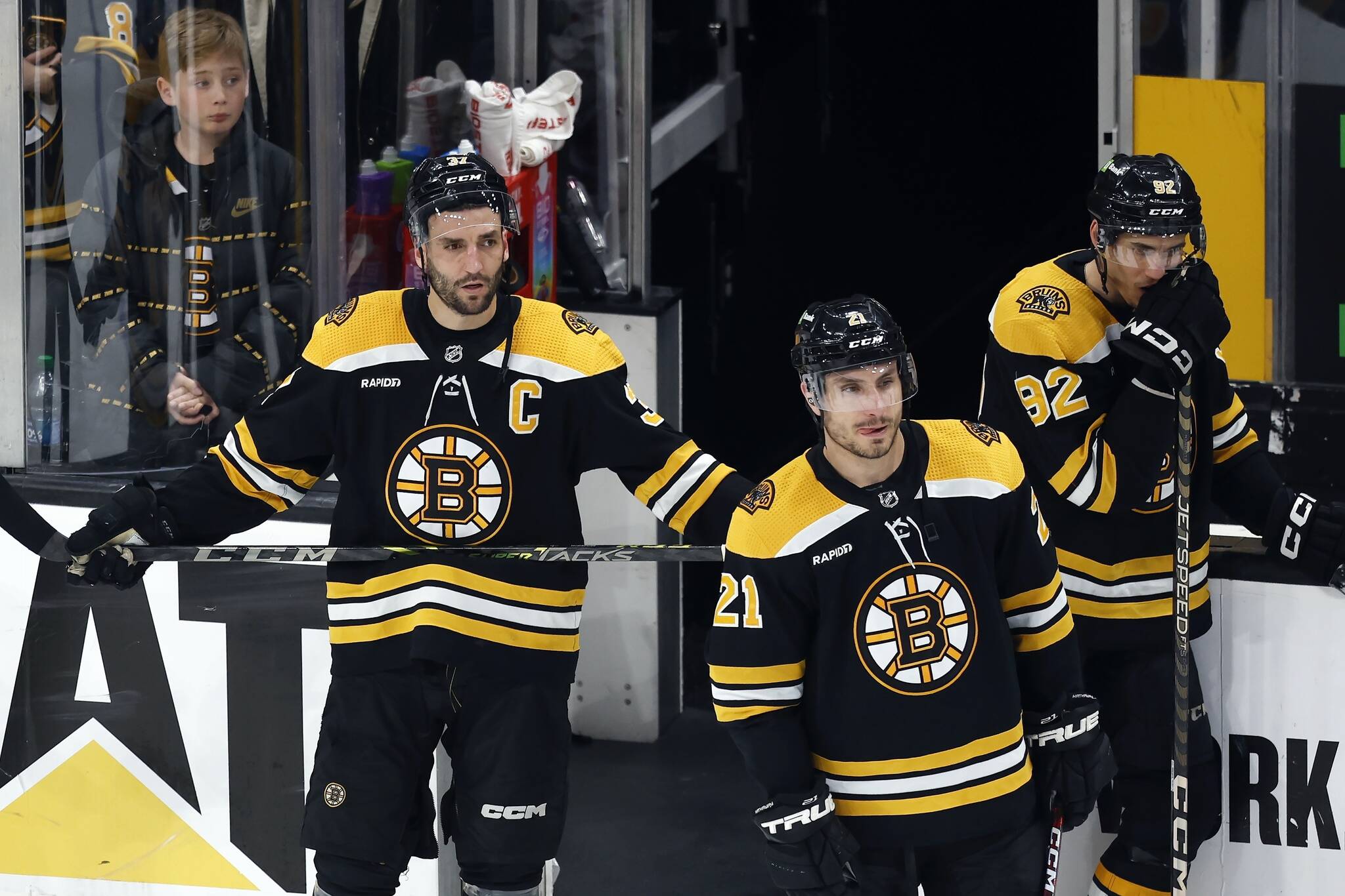 Boston Bruins’ Patrice Bergeron (37) stands with Garnet Hathaway (21) and Tomas Nosek (92) after losing to the Florida Panthers in overtime during Game 7 of an NHL hockey Stanley Cup first-round playoff series, Sunday, April 30, 2023, in Boston. (AP Photo/Michael Dwyer)