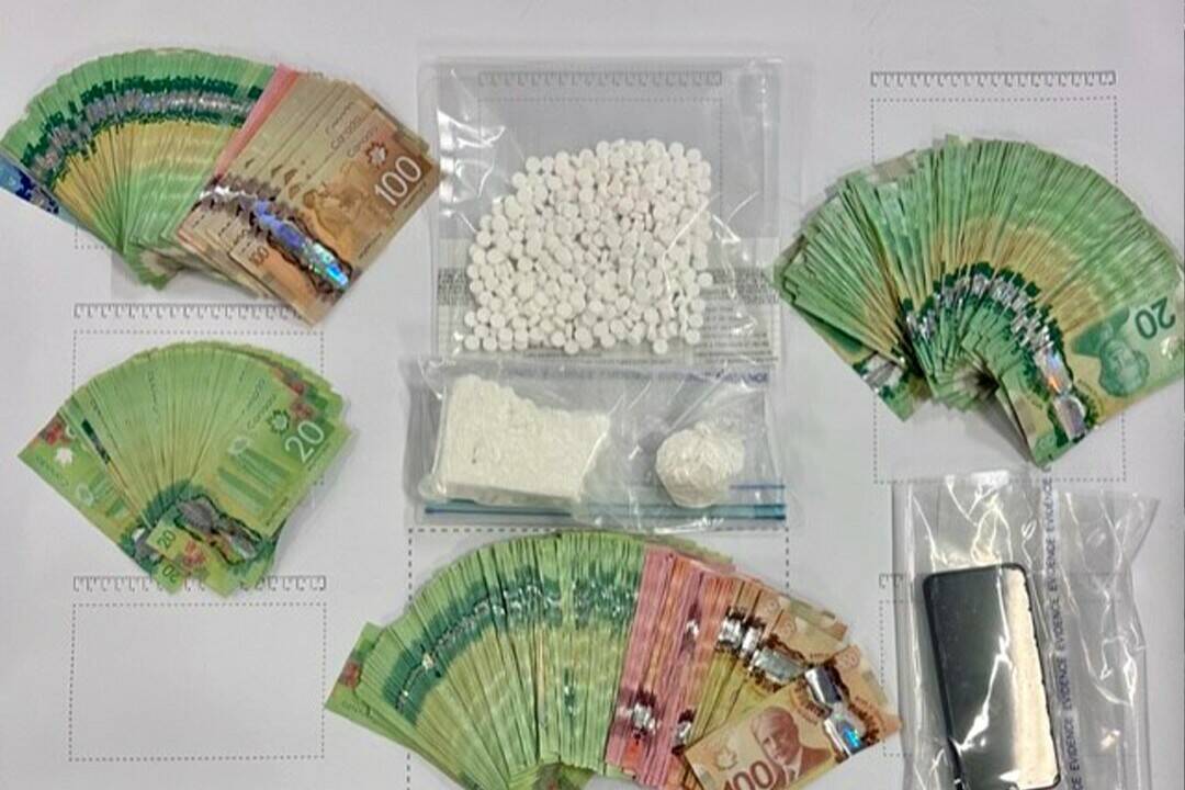 Cash and illicit drugs are photographed by B.C. police after seizing roughly 2kg of street drugs and roughly $70,000 in cash in the first three months of 2023. (Photo CFSEU-BC)