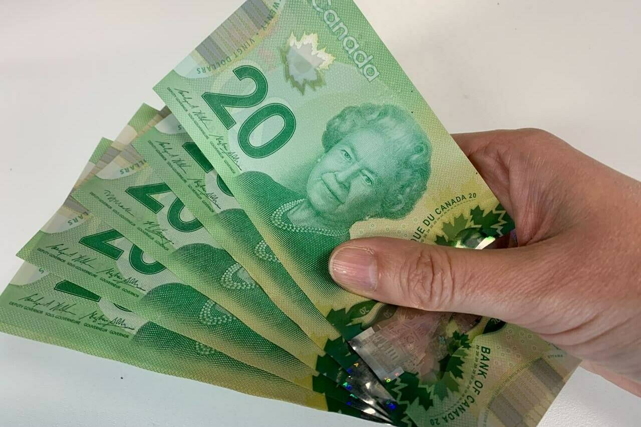 Canadian $20 bills are pictured in Toronto on September 9, 2022. Countries around the world whose currencies pay tribute to the late Queen Elizabeth II now have a new monarch — and a decision to make about whether the King has a place on their money. THE CANADIAN PRESS/Staff