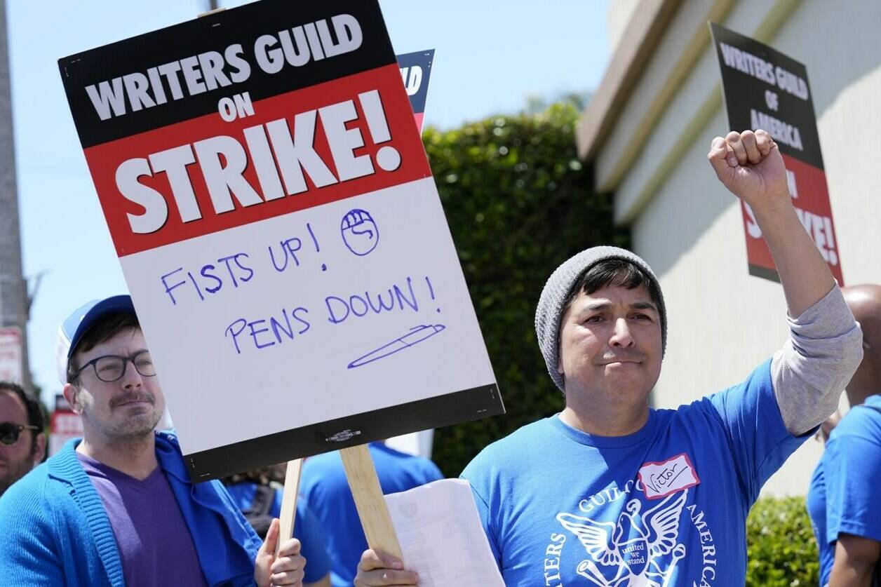 Writers Guild of America West member Victor Duenas pickets with others at an entrance to Paramount Pictures, Tuesday, May 2, 2023, in Los Angeles. The first Hollywood strike in 15 years began Tuesday as the economic pressures of the streaming era prompted unionized TV and film writers to picket for better pay outside major studios, a work stoppage that already is leading most late-night shows to air reruns. (AP Photo/Chris Pizzello)