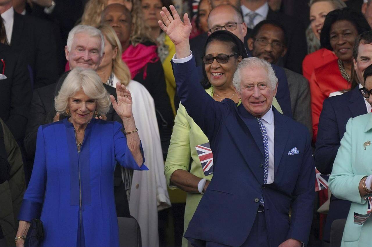 King Charles III and Queen Camilla wave from the Royal Box ahead of the concert at Windsor Castle in Windsor, England, Sunday, May 7, 2023, celebrating the coronation of King Charles III. It is one of several events over a three-day weekend of celebrations. (Yui Mok/Pool Photo via AP)