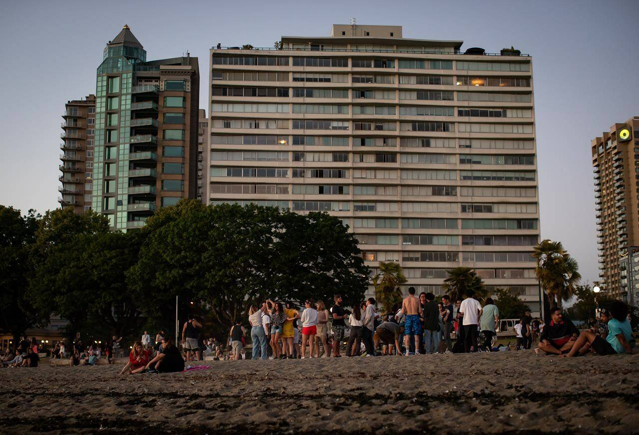 People gather at English Bay Beach amidst a heat wave, in Vancouver, B.C., on Monday, June 21, 2021. The BC Green Leader Sonia Furstenau is calling on the province to implement more recommendations from the BC Coroners Service report into the deadly 2021 heat dome. THE CANADIAN PRESS/Darryl Dyck