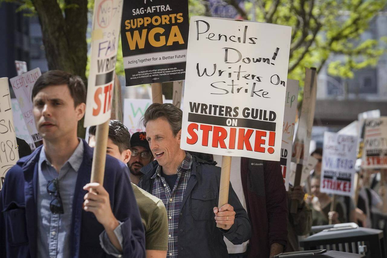 Late night talk show host Seth Meyers, right, joins striking members of the Writers Guild of America on the picket line during a rally outside Silvercup Studios, Tuesday May 9, 2023, in New York. (AP Photo/Bebeto Matthews)