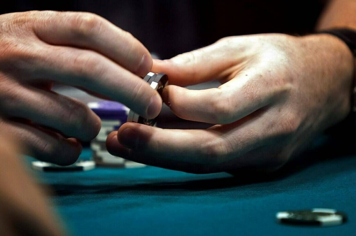 Everyone who enters a British Columbia casino will soon be required to present government-issued identification, in what the BC Lottery Corporation says is an initiative to support people who have registered for self-exclusion. A poker player twirls his chips while playing his hand during a game at a poker championship in Calgary, Wednesday, Aug. 25, 2010. THE CANADIAN PRESS/Jeff McIntosh