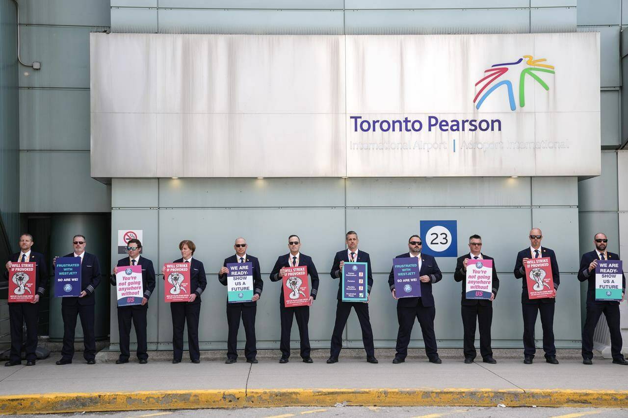 WestJet Airlines pilots stand on a picket line at Toronto’s Pearson Airport on Monday May 8, 2023. The travel plans of WestJet customers are up in the air after its pilots’ union issued a 72-hour strike notice last night. THE CANADIAN PRESS/Chris Young