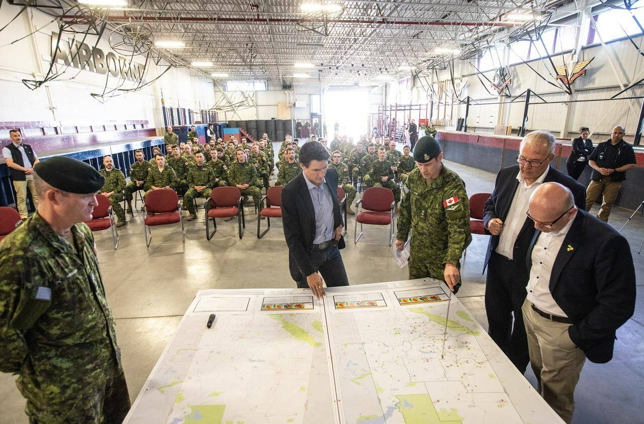 From left, General Steve Graham, Prime Minister Justin Trudeau, Colonel Ben Schmidt, MP Bill Blair and MP Randy Boissonnault meet with members of the Canadian Armed Forces who are assisting in the Alberta wildfires, in Edmonton on Monday, May 15, 2023. THE CANADIAN PRESS/Jason Franson