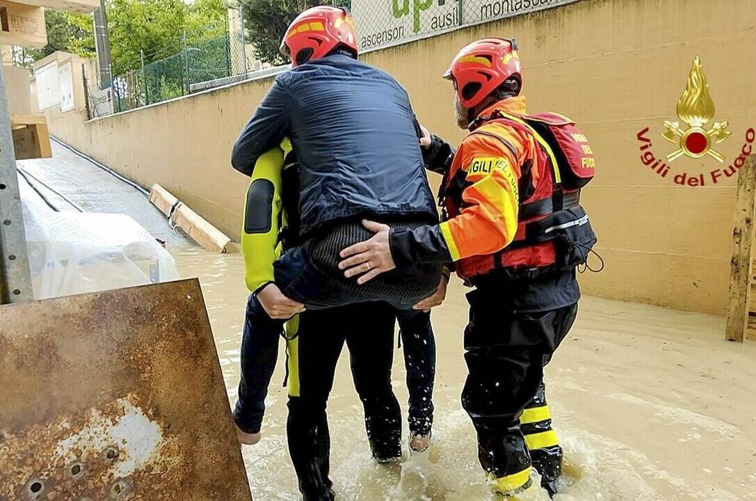 This photo provided by the Italian Firefighters shows firefighters rescuing a person from a flooded house in Riccione, in the northern Italian region of Emilia Romagna, Tuesday, May 16, 2023. Unusually heavy rains have caused major flooding in Emilia Romagna, where trains were stopped and schools were closed in many towns while people were asked to leave the ground floors of their homes and to avoid going out. (Vigili del Fuoco via AP)