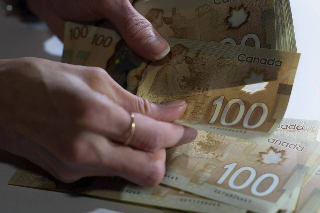 Canadian $100 bills are counted in Toronto, Feb. 2, 2016. In an era inundated with scams involving mysterious princes or easy fortunes — if you just hand over a few bucks in advance — you’re probably right to be wary of anyone offering free money. But Sherry MacLennan and Lindsey Moore really might have some cash for British Columbians. Maybe even millions. THE CANADIAN PRESS/Graeme Roy