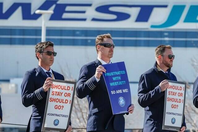 Members of the Air Line Pilots Association demonstrate amid contract negotiations outside the WestJet headquarters in Calgary, Alta., Friday, March 31, 2023. Talks between WestJet and the pilots’ union continue as the clock counts down toward a Friday strike deadline. THE CANADIAN PRESS/Jeff McIntosh