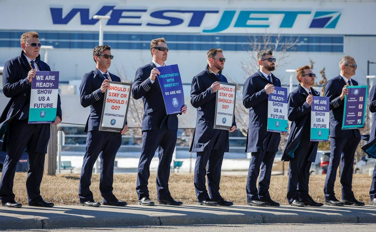 Members of the Air Line Pilots Association demonstrate amid contract negotiations outside the WestJet headquarters in Calgary, Alta., Friday, March 31, 2023. WestJet has started to cancel flights as talks with the pilots’ union remained at a “critical impasse,” the company said Thursday, jeopardizing travel plans for thousands of passengers ahead of the May long weekend. THE CANADIAN PRESS/Jeff McIntosh