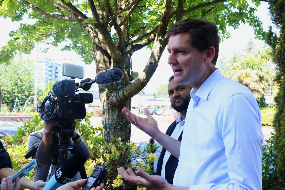 B.C. Premier David Eby talks with the media in Langford on May 25 alongside NDP candidate for the Langford-Juan de Fuca byelection Ravi Parmar. Eby will lead a trade delegation to Asia starting May 27. (Bailey Moreton/News Staff)