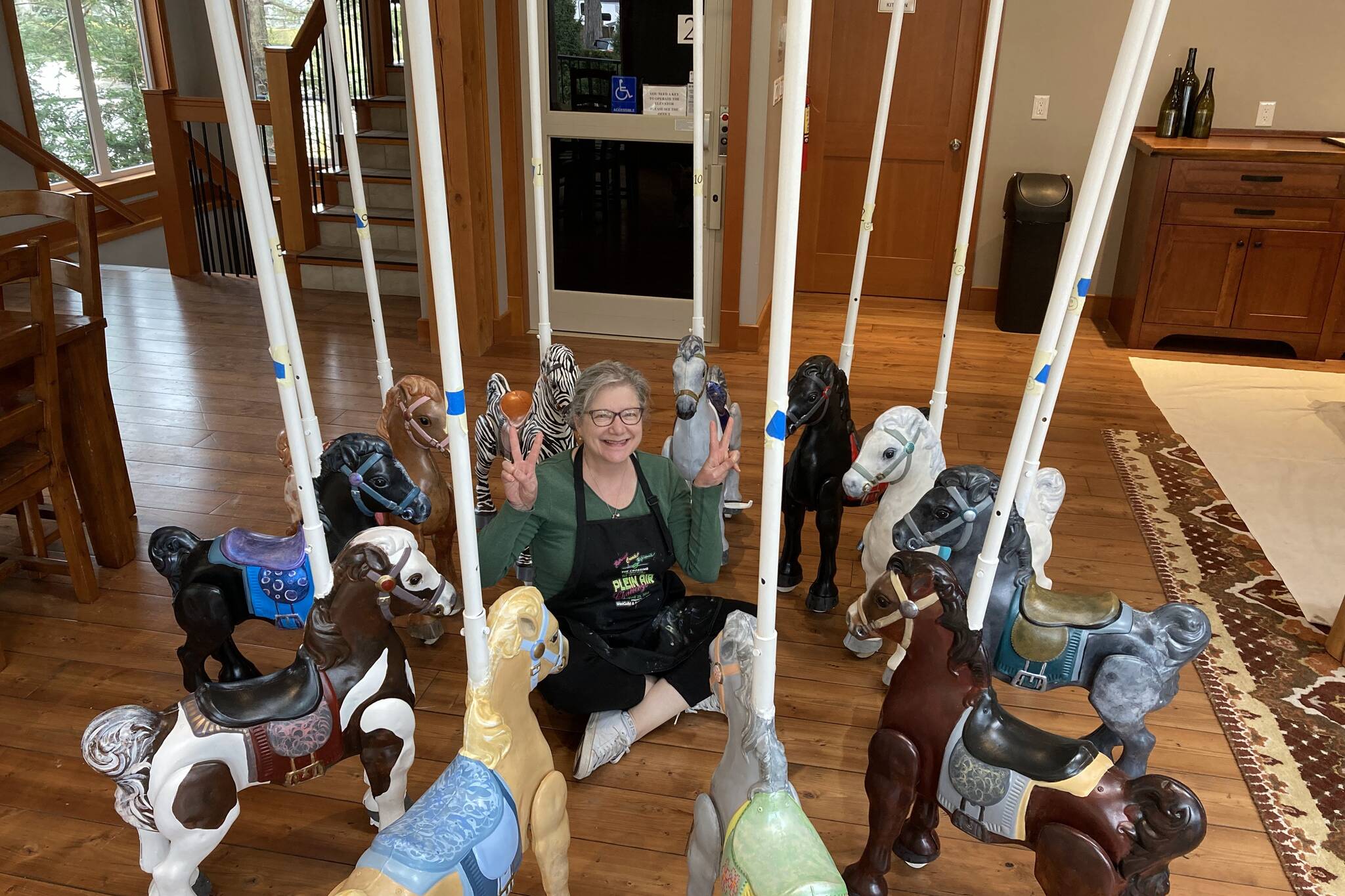 Artist Annette Resler poses, surrounded by recently restored carousel ponies. The carousel has made an appearance across the Lower Mainland, including in Vancouver, Chilliwack and here in Agassiz. (Photo/Annette Resler)