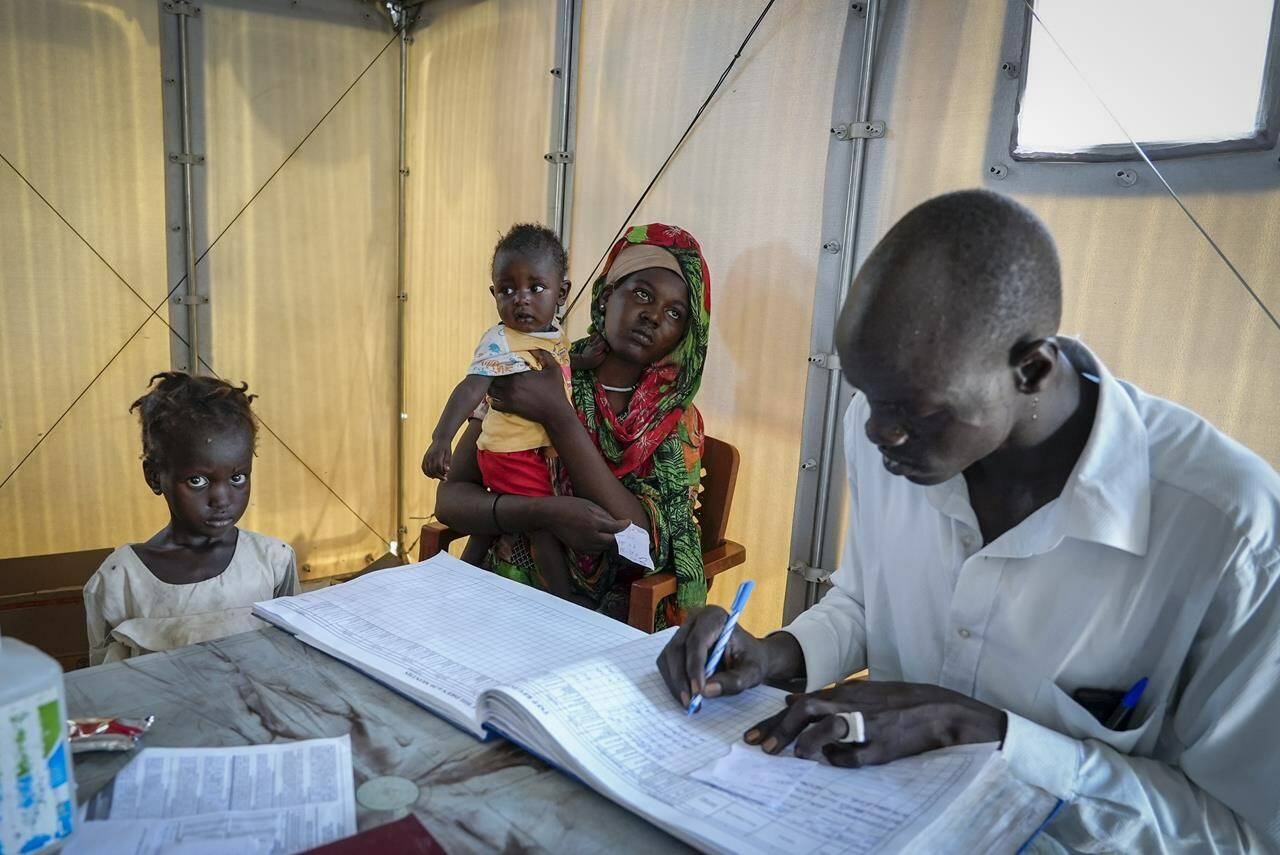 A health worker assesses malnourished South Sudanese children at a clinic in a transit center in Renk, South Sudan Wednesday, May 17, 2023. Tens of thousands of South Sudanese are flocking home from neighboring Sudan, which erupted in violence last month. (AP Photo/Sam Mednick)