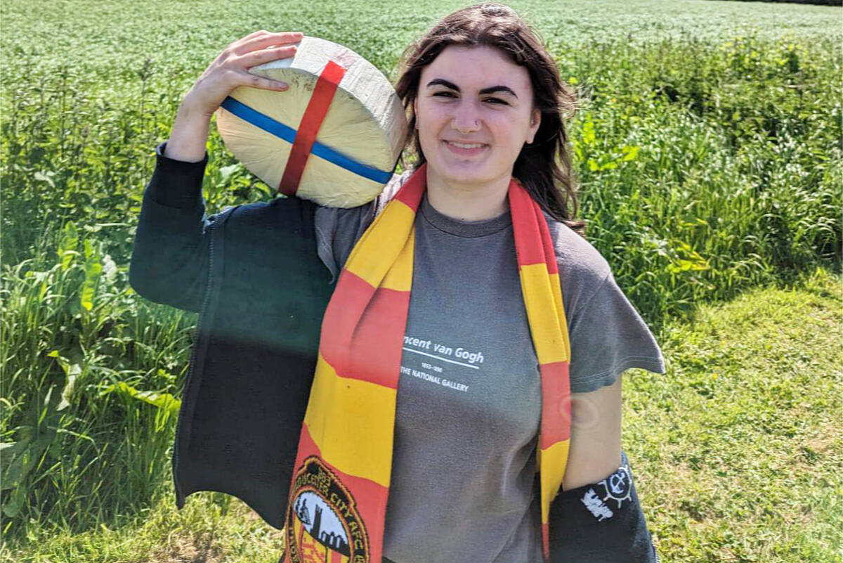 Delaney Irving, of Nanaimo, is bringing home the big cheese after winning the Cooper’s Hill Cheese-Rolling women’s event near Gloucester, England, on Monday, May 29. (John Gilmour photo)