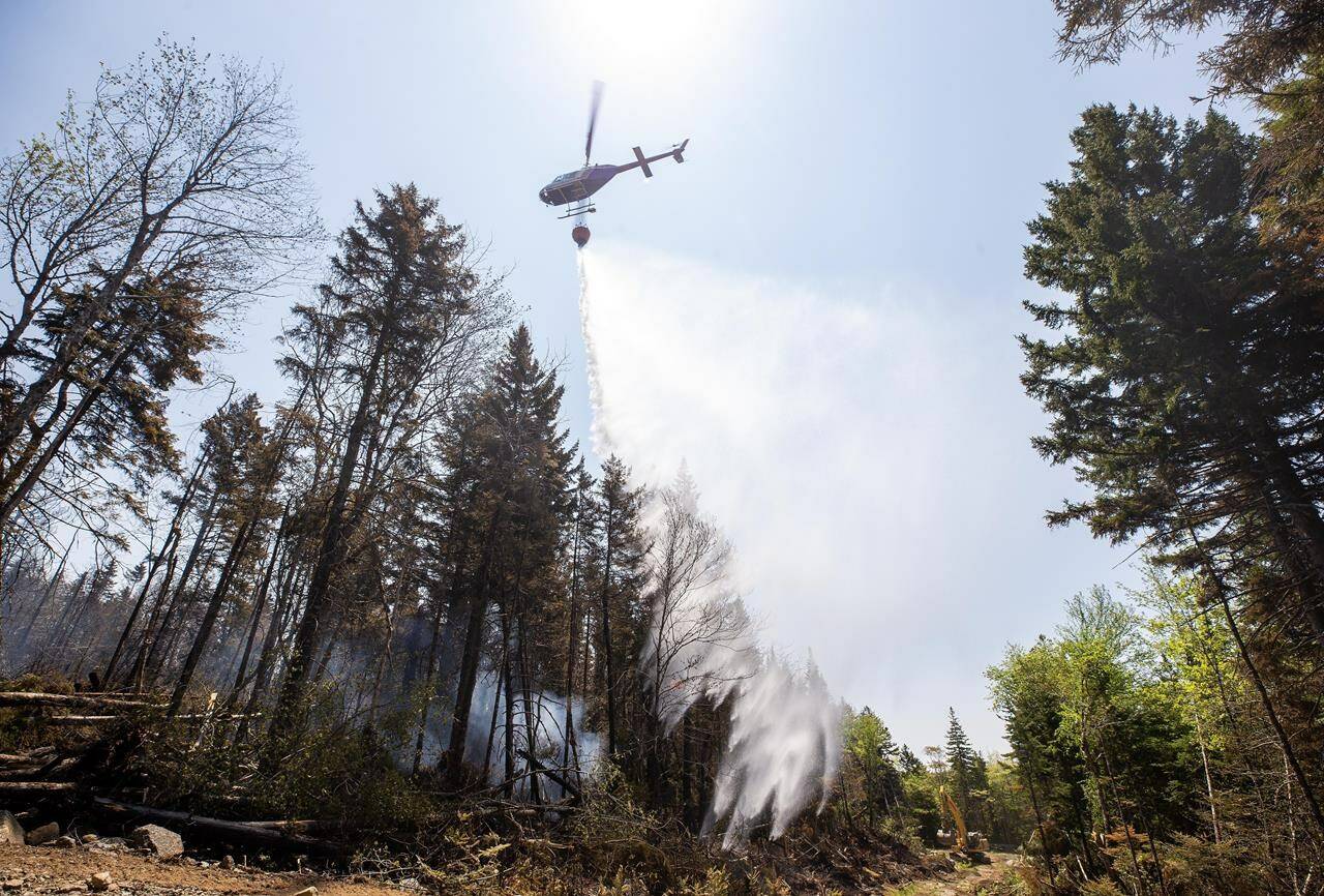 A helicopter drops water on a hot spot at a wildfire in Tantallon, N.S. in this Thursday, June 1, 2023 handout photo. THE CANADIAN PRESS/HO, Communications Nova Scotia