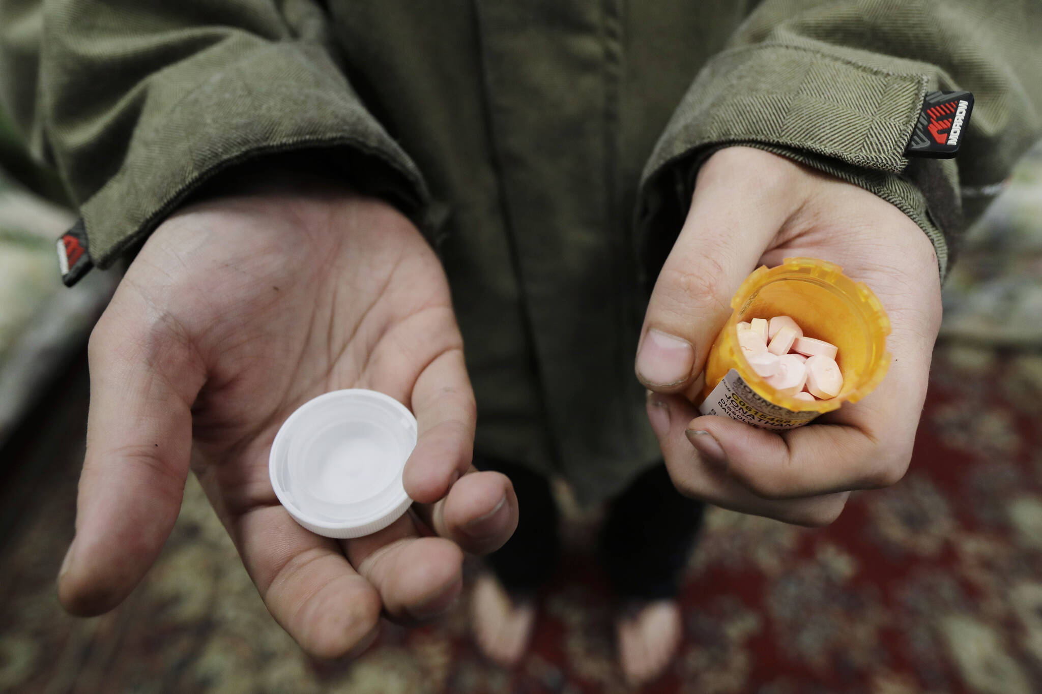 FILE - In this Nov. 14, 2019, photo, Jon Combes holds his bottle of buprenorphine, a medicine that prevents withdrawal sickness in people trying to stop using opiates, as he prepares to take a dose in a clinic in Olympia, Wash. (AP Photo/Ted S. Warren, File)