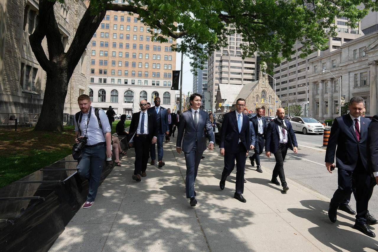 Prime Minister Justin Trudeau walks along a street with Poland Prime Minister Mateusz Morawiecki on their way to an announcement in Toronto on Friday June 2, 2023. Trudeau says that he raised concerns about reports that LGBTQ rights and democracy are under threat in Poland during a Friday visit with Morawiecki in Toronto. THE CANADIAN PRESS/Chris Young