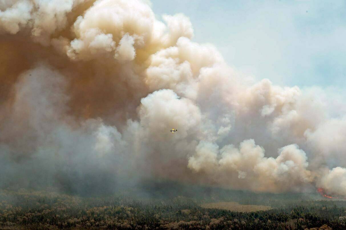 An aircraft (centre) disperses a mix of water and fire retardant over a fire near Barrington Lake in Shelburne County, N.S. in this Wednesday, May 31, 2023 handout photo. The fires plaguing residents in Alberta and Nova Scotia are part of a larger trend that’s driving up the cost of home insurance as extreme weather becomes more common, insurance experts said. THE CANADIAN PRESS/HO-Communications Nova Scotia **MANDATORY CREDIT**