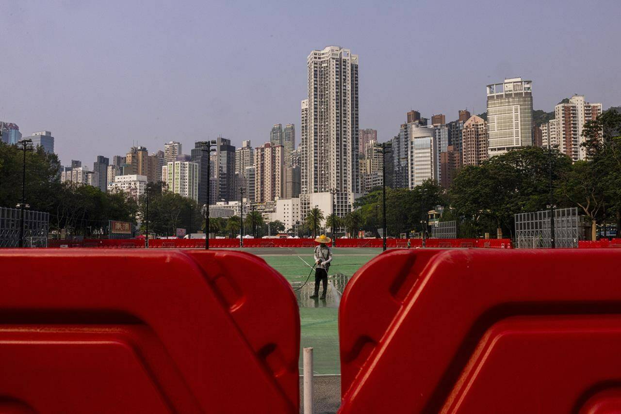 A worker sprays water on Victoria Park in Hong Kong, as government closed parts of traditional venue of the city’s annual Tiananmen crackdown vigil for “maintenance works”, on Tuesday, May 30, 2023. THE CANADIAN PRESS/AP-Louise Delmotte
