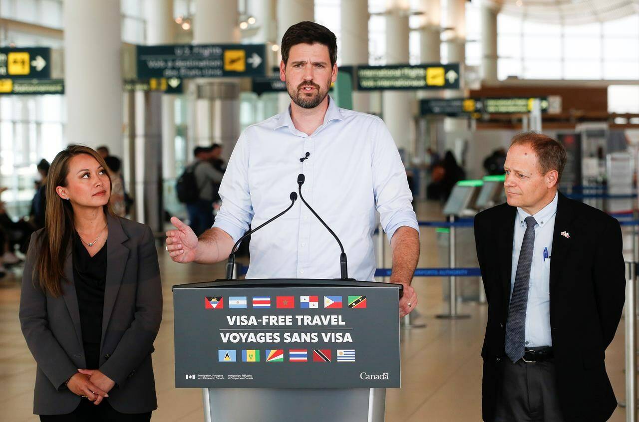 Sean Fraser, Minister of Immigration, Refugees and Citizenship, centre, Rechie Valdez, Member of Parliament for Mississauga, and Kevin Lamoureux, Member of Parliament for Winnipeg North, make an announcement regarding visa-free travel in the Winnipeg airport, Tuesday, June 6, 2023. THE CANADIAN PRESS/John Woods