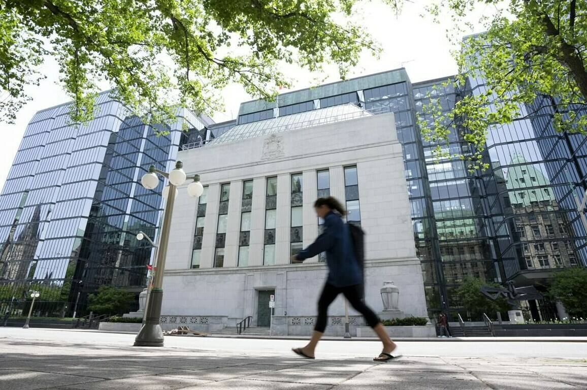 The Bank of Canada is set to announce its interest rate decision this morning as speculation about another rate hike heats up. A woman walks past the Bank of Canada headquarters, Wednesday, June 1, 2022 in Ottawa. THE CANADIAN PRESS/Adrian Wyld