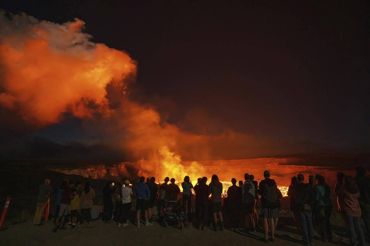 This photo provided by Janice Wei shows people watching the eruption inside the summit crater of the Kilauea volcano on the Big Island of Hawaii, Thursday, Jan. 5, 2023. Kilauea, one of the world’s most active volcanoes, is erupting again and providing a spectacle that includes bursting lava fountains and lava “waves” but no Big Island communities are in danger. (Janice Wei via AP)
