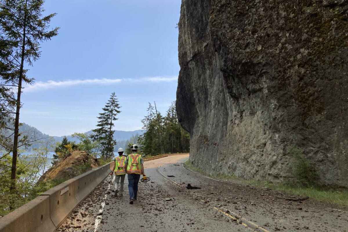 Two workers walk along Highway 4 around Angel Rock conducting a geotechnical assessment prior to June 8, 2023. The Cameron Bluffs wildfire has closed Highway 4 between Parksville and Port Alberni. (B.C. MINISTRY OF TRANSPORTATION PHOTO)