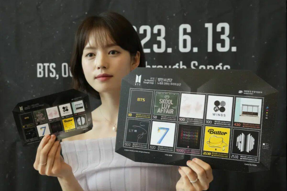 A model shows sheets of postage stamps marking the 10th debut anniversary of K-pop band BTS at a post office in Seoul, South Korea, Monday, June 12, 2023. Post offices start selling the stamps Tuesday. (AP Photo/Ahn Young-joon)