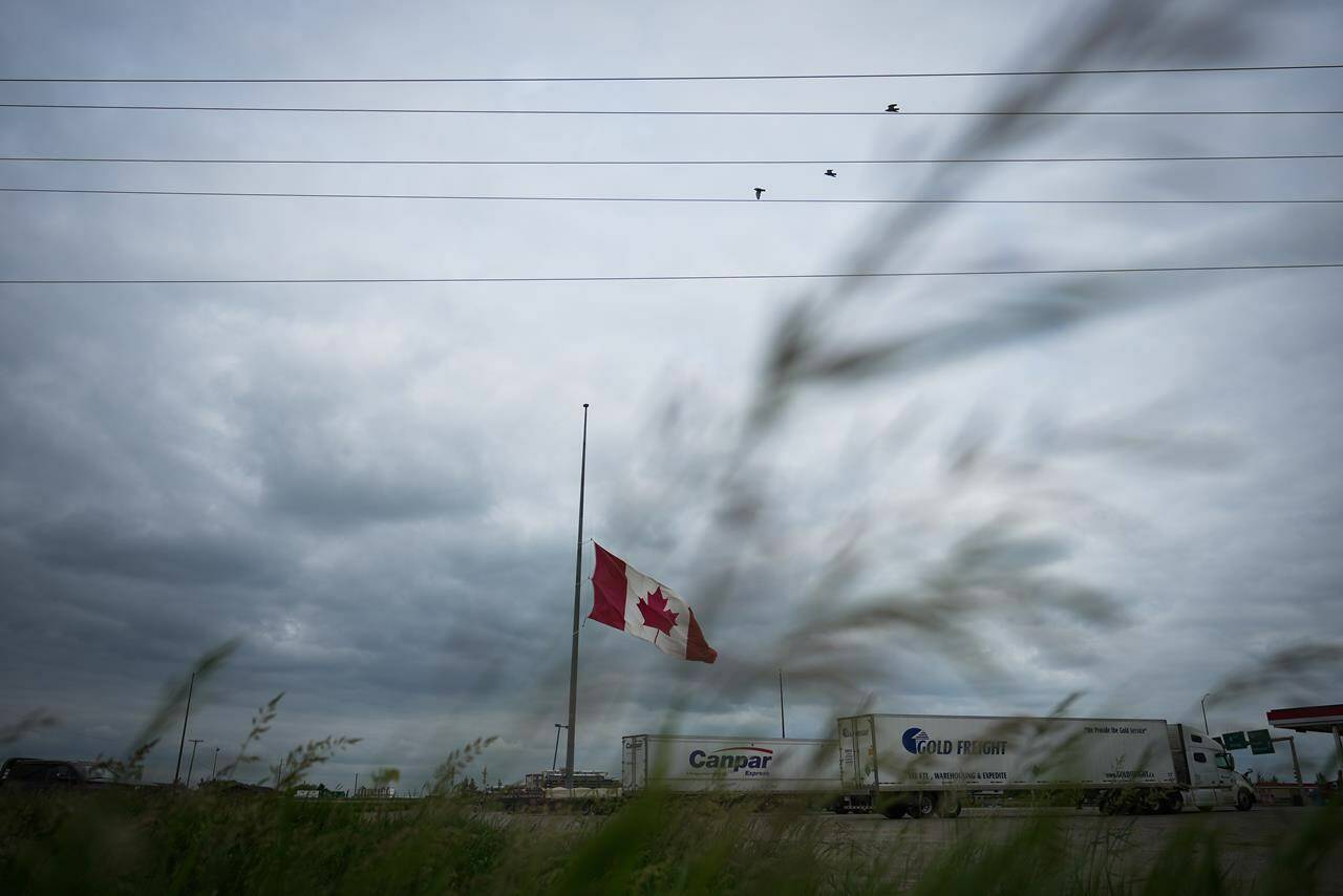 A Canadian flag flies at half-mast at a truck stop in Brandon, Man., on Friday, June 16, 2023, to honour the victims of a bus crash in Carberry, on the Trans-Canada Highway west of Winnipeg. THE CANADIAN PRESS/Darryl Dyck